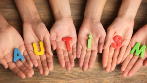 hands holding the letters that spell out autism