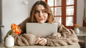 young woman looking confused with her laptop