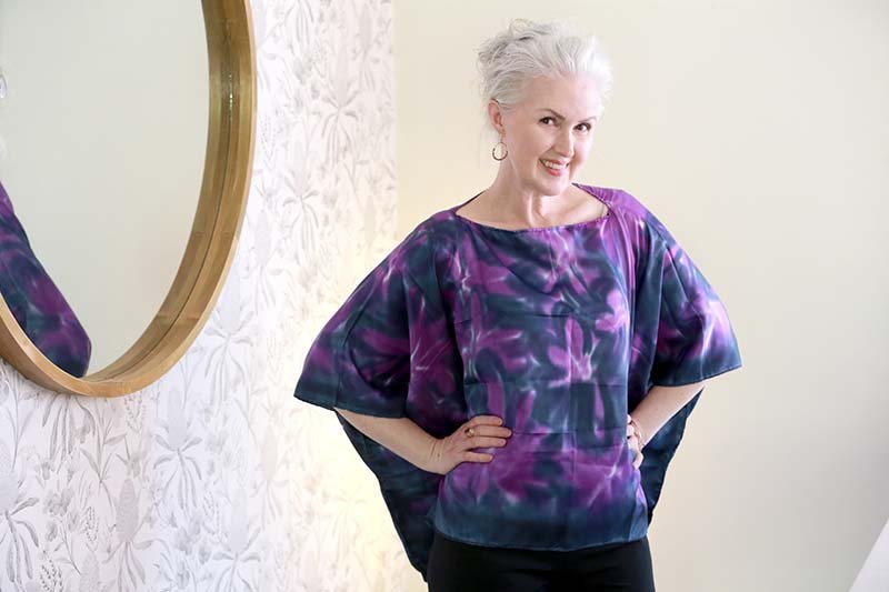 Rini wearing a batwing style silk top in purple art print