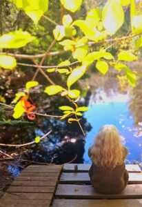 rini sitting down comtemplating feelings at the lake