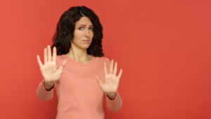 woman holding up her hands to refuse and say no