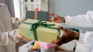 two people exchanging gifts presents