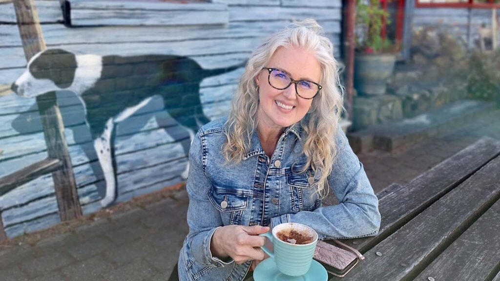 Rini sitting outside with a cup of coffee in Sheffield, Tasmania